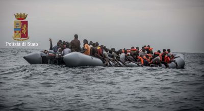 rescue 146, Libyan man with hand raised. Man in orange with dreads is Barri from George Town, Gambia. He knows the photogarphers friend Mark Thompson