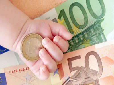 Hand von einem Baby mit Geld